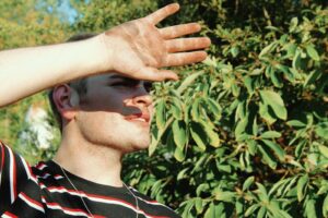 man shielding his face with his right hand